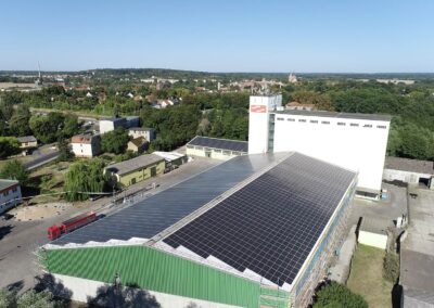 Blauer Himmel im Hintergrund und Solarmodule auf Hallendach